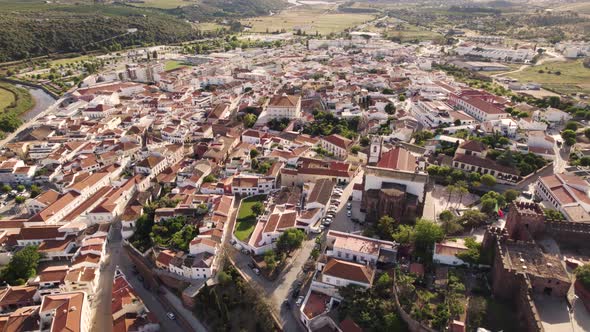 Rotating aerial shot of the historic city center of Silves in the Portuguese region of Algarve. alt