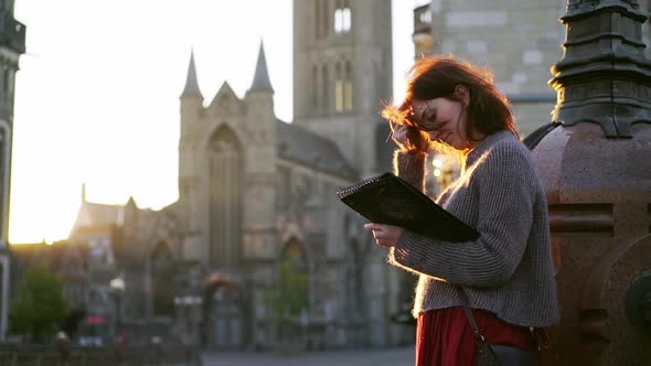 Lady in Sweater Draws on City Street