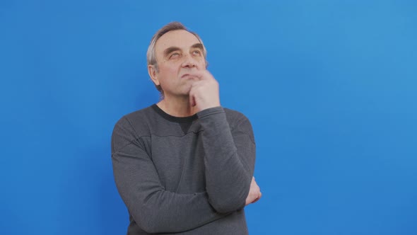 Thinking Elderly Man Looking Up Around Blue Background alt