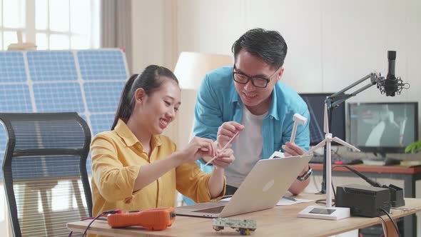 Asian Man And Woman Discuss About Work With Wind Turbine And Laptop Computer alt