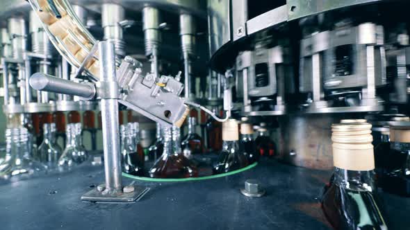 Factory Mechanism with Bottles of Cognac Being Relocated By It alt