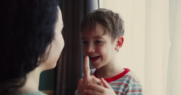 Portrait of Mother and Son Mother Strokes the Nose of Her Smiling Son with Her Finger the Child is alt