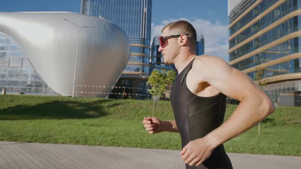 Pro Runner Runs on a City Road Athlete Trains in an Urban Environment on a Sunny Day Modern Urban alt