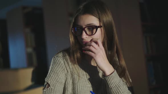 Young Girl Noting Information From Books Thinking and Smiles in Library alt