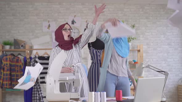 Two Positive Young Muslim Women Fashion Designers in National Headscarves Throw Papers for Joy Slow alt