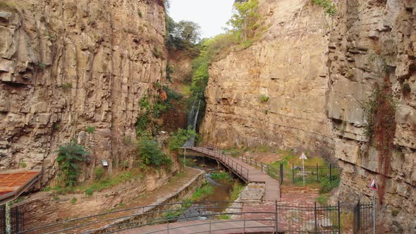 Tranquil Cinematic View Of Waterfall With Empty Pathway In Tbilisi, Georgia. alt