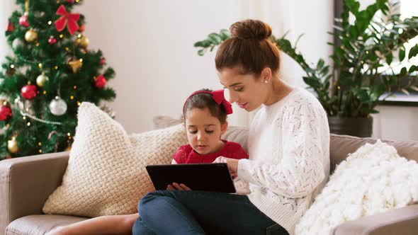 Mother and Daughter with Tablet Pc on Christmas alt