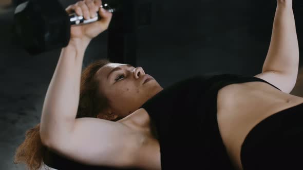 Closeup Young Beautiful Redhead Athletic Woman Exercising with Dumbbells on Bench in Gym alt