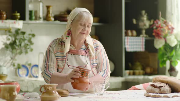Grandmother Pouring Milk Into the Glass From Crock in the Country alt