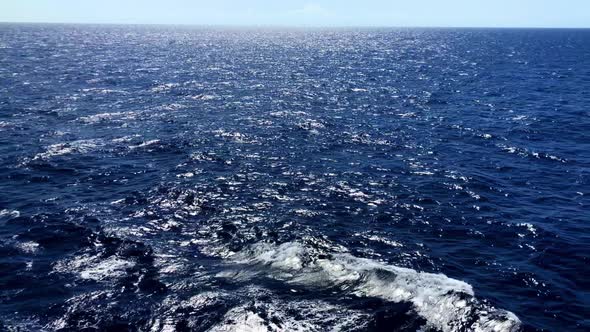 Ocean waves as the sun reflects on the frothy rolling waters in slow motion alt