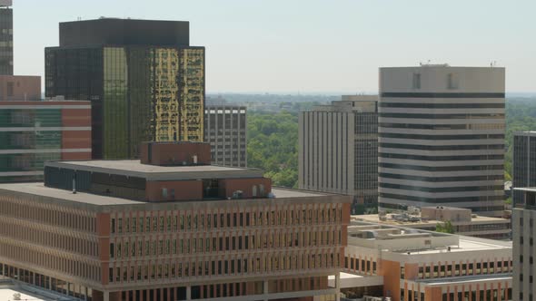 Aerial midlevel view of downtown city with a pan showing skyline. alt