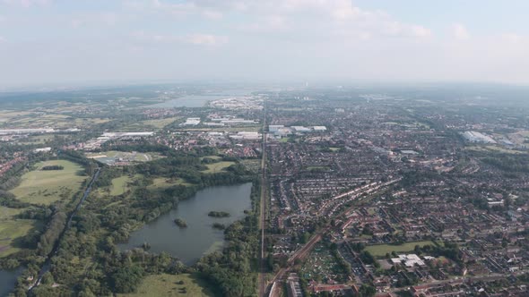 High drone shot of long straight train tracks separating UK town from natural reserve alt