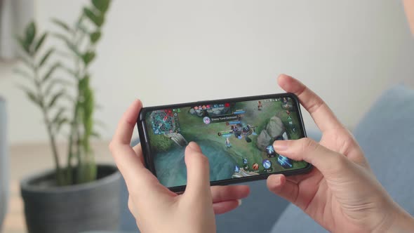 Female Playing Game On Smartphone alt