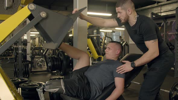 Young Man with Prosthetic Leg Using Leg Press Machine in Gym