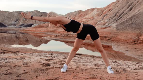 Woman working out on lifeless dried locality