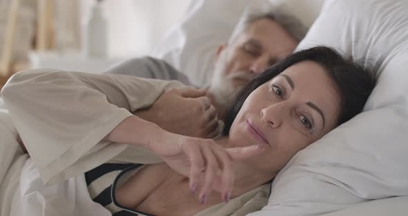 Close-up of Senior Caucasian Brunette Woman with Grey Eyes Showing Hush Gesture As Lying alt