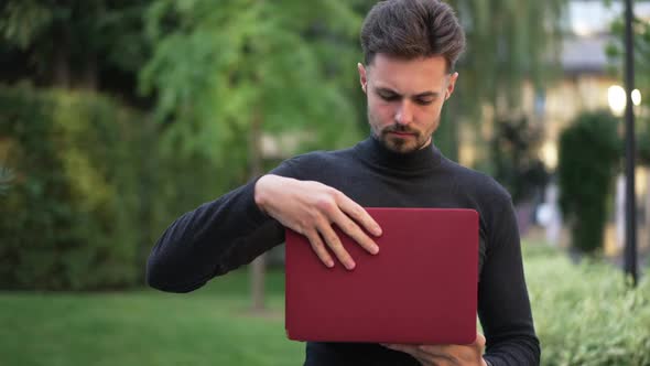 Portrait of Caucasian Young Businessman Closing Laptop Looking at Camera with Confident Facial alt