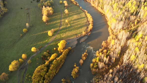 Aerial View From Drone Over a Curve River, Fall Bald Forest and Country Road.