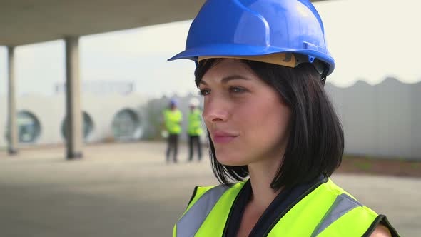 Architect woman confidently looking at camera at construction site