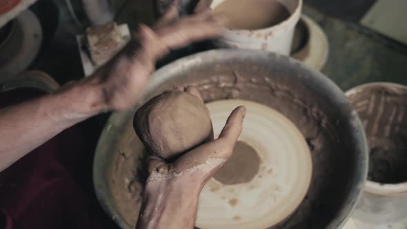 Potter Shapes the Clay Product with Pottery Tools on the Potter's Wheel Top View Toned Cinematic alt