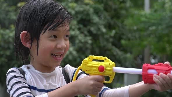 Cute Asian Child Playing With Water Gun In The Summer alt
