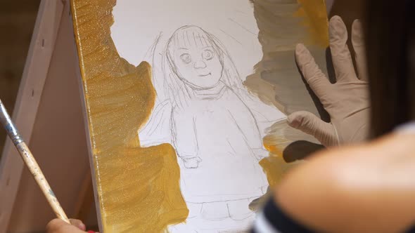 A Beginner Artist Draws with Brush Around Pencil Scetch Using Oil Paints on White Canvas