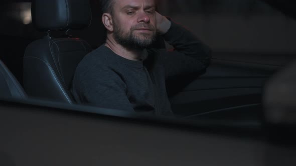 Man Sits in a Car Upset That He Was Stopped By the Police for a Traffic Violation alt