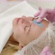 Close Up, A Beautician In Pink Gloves, Applies A Blue Cosmetic Face Mask On A Woman&#39;s Face.  - VideoHive Item for Sale