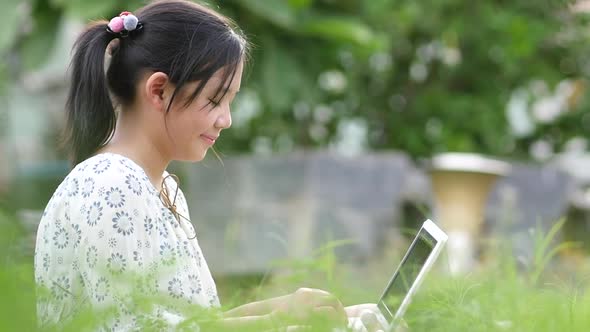 Beautiful Asian Girl Sitting In Park On The Green Grass With Laptop alt