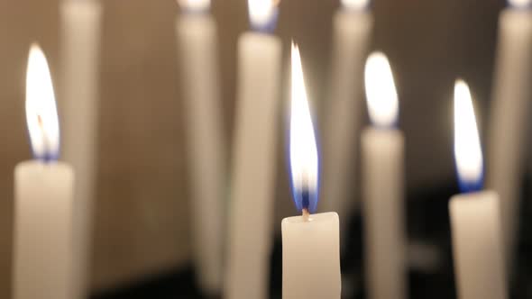 Made of wax white votive candles burning in the cathedral hall 4K 2160p 30fps UHD video - Slow burni alt