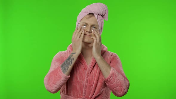 Portrait of Transsexual Man in Bathrobe Looking in Mirror Wearing Eye Patches alt