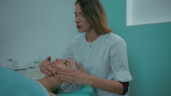 Cleaning the Girl's Face Before the Procedure of the Beautician in the Office