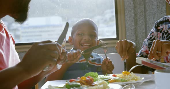 Family having food at dining table in a comfortable home 4k alt