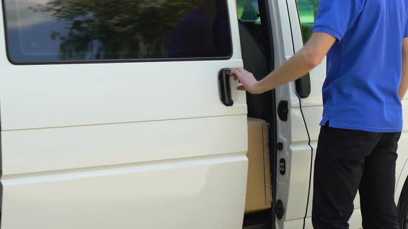 Delivery Man Opening Door of Company Car and Taking Parcel, Express Delivery alt