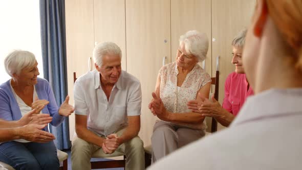 Group of senior friends clapping hands alt