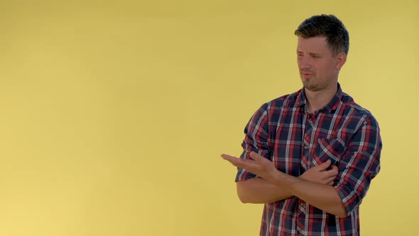 Handsome Young Man Disliking Something and Giving Thumbs Down alt