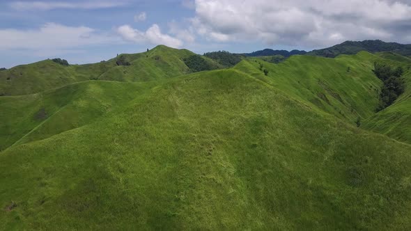 Aerial View. Flight Over a Green Grassy Rocky Hills