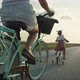 Rear view of family of four caucasian people riding bikes on village road. Shot with RED helium came - VideoHive Item for Sale