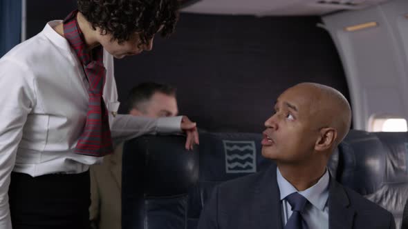 Flight attendant talking to passengers on airplane