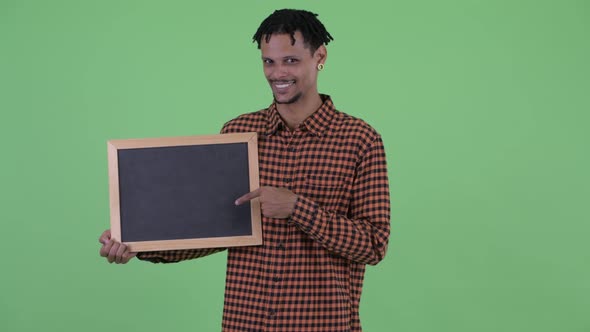 Happy Young African Man Holding Blackboard and Giving Thumbs Up alt