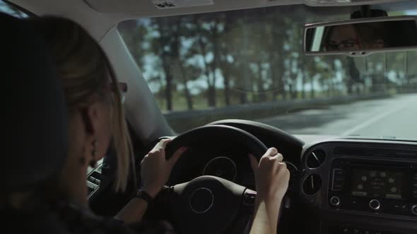 Beautiful Female Driver Driving Car on Motorway alt