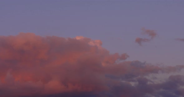 Epic time lapse of pink clouds rolling through the sky at sunset. alt