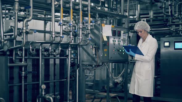 Factory Expert Is Recording Data From Electronic Equipment alt