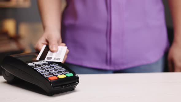 Woman Hands Making Payment With Credit Card Machine Terminal to Pay the Bill NFC