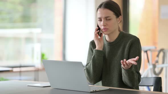 Angry Woman Talking on Phone at Work alt