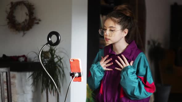 young influencer girl records video on her phone for social media at home alt