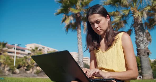 Freelance Woman Working with Laptop Computer and Drinks Water From Bottle alt