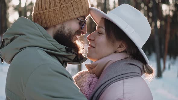 Romantic Stylish Couple Talk and Kiss in the Forrest on a Sunny Winter Day