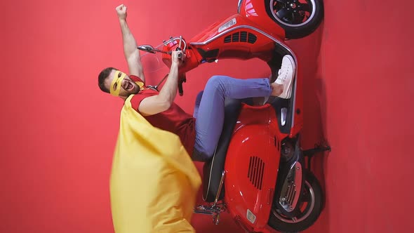 Portrait of a Superhero on a Scooter, a Man in a Raincoat and Mask Rides a Scooter, Motorcycle alt