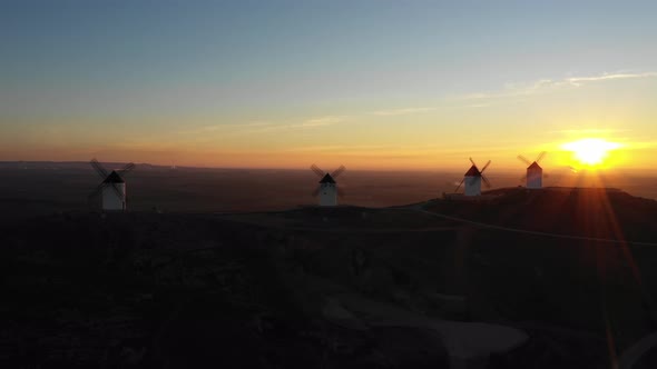 Aerial view of windmills in the countryside in Spain at sunrise alt